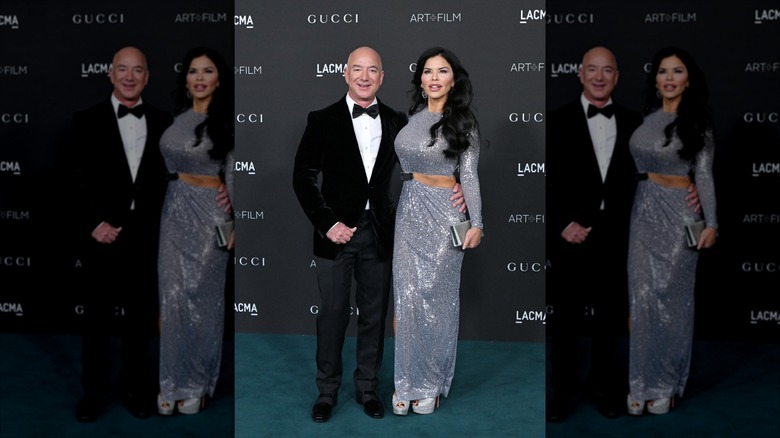 Lauren Sánchez Bezos posa junto a Jeff Bezos (izquierda) con un vestido plateado.