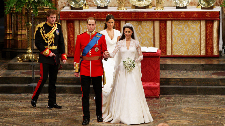 Kate Middleton con su vestido de novia de la mano del príncipe William mientras se preparan para partir