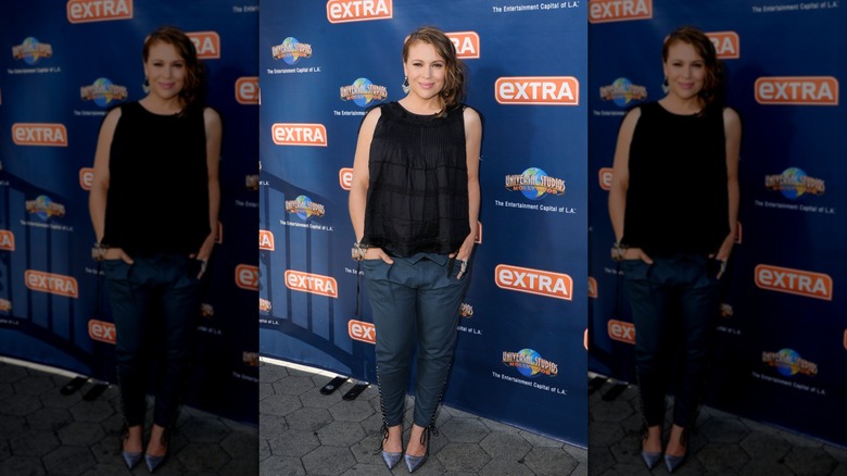 Alyssa Milano con un top fluido y pantalones ajustados durante el embarazo