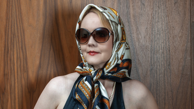 una mujer mayor con estilo que complementa con un pañuelo de seda