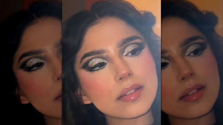 Selfie de mujer con sombra de ojos brillante y labios brillantes.