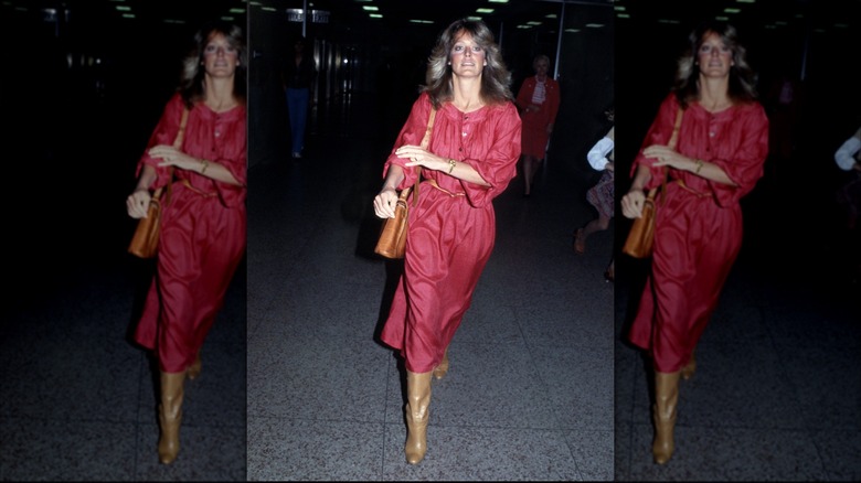 Farrah Fawcett lleva un vestido rojo y botas marrones