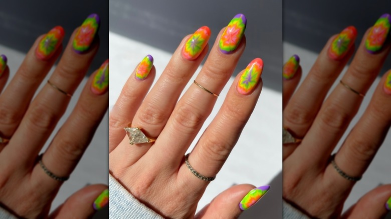 Una imagen de cerca de una colorida manicura tie-dye.