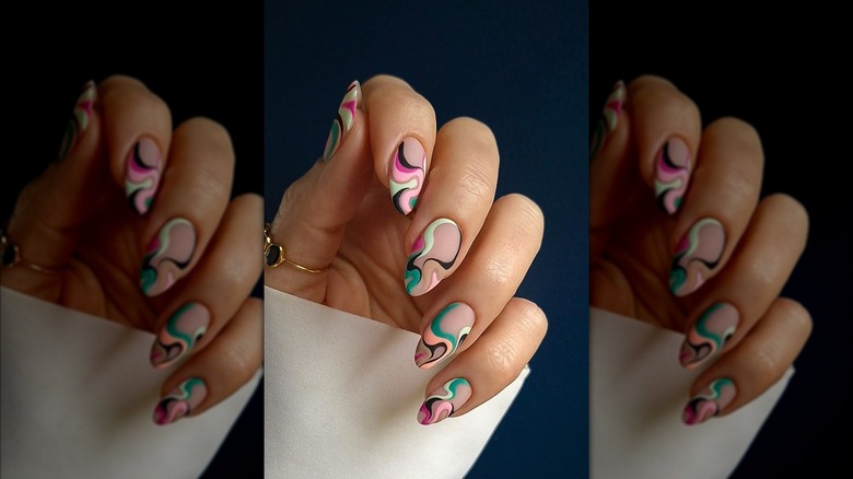 Primer plano de una manicura con remolinos de colores.