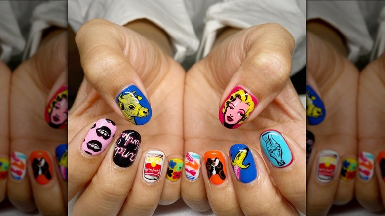 Imagen de cerca de una manicura inspirada en Andy Warhol con varios diseños gráficos.