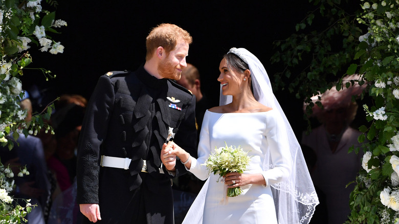 El príncipe Harry y Meghan Markle fotografiados el día de su boda sonriéndose el uno al otro.