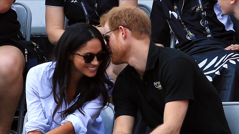 El príncipe Harry susurra al oído de Meghan Markle mientras ella sonríe en los Juegos Invictus 2017.