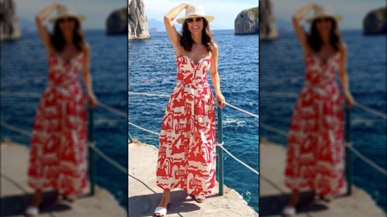 Kaitlan Collins posando para una foto en Italia con un vestido de verano y un sombrero