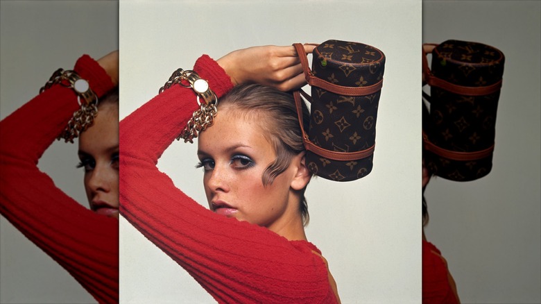 Twiggy posa para una sesión de fotos con sombra de ojos azul y un top rojo