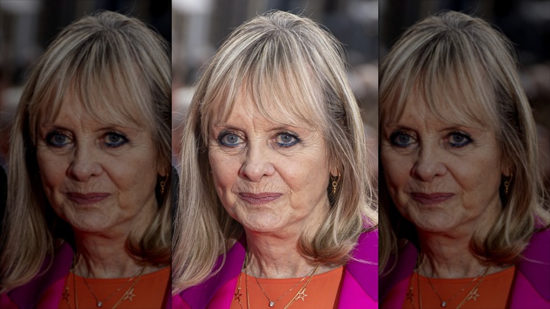 Twiggy sonríe con sombra de ojos color bronce y delineador de ojos azul.