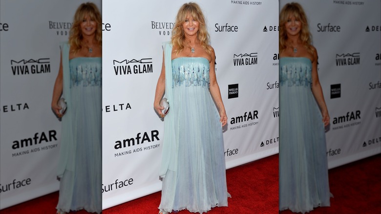 Goldie Hawn posando en un evento de alfombra roja en 2013 con un vestido azul claro.