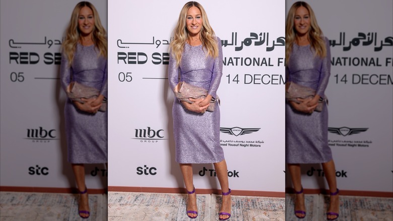 Sarah Jessica Parker posando en un evento con un vestido de manga larga color lila en 2024.