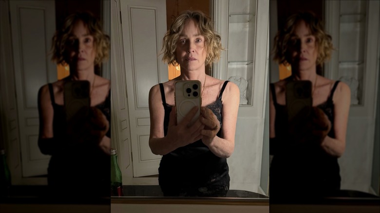 Sharon Stone posando para una selfie en el espejo con el cabello desordenado y sin maquillaje.
