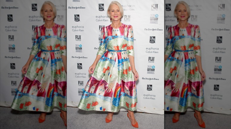 Helen Mirren posando en un evento en 2015 luciendo un vestido colorido con zapatos naranjas.