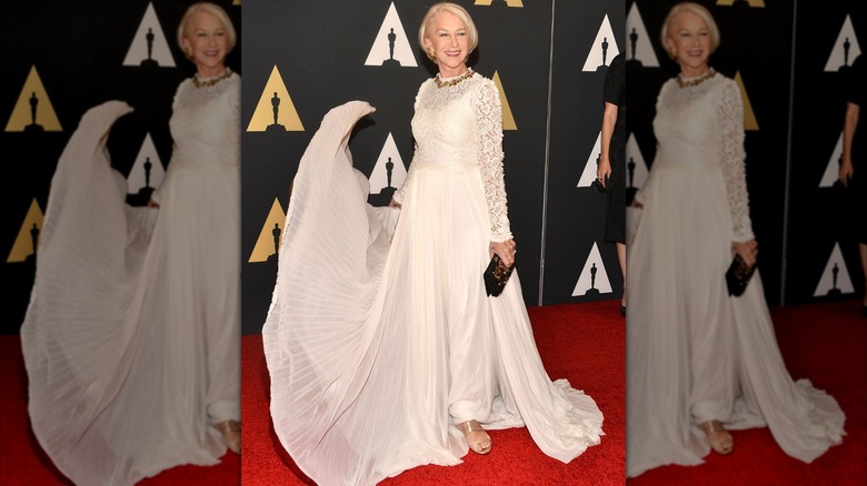 Helen Mirren sonriendo en la alfombra roja en 2015 con un vestido blanco con falda suelta.