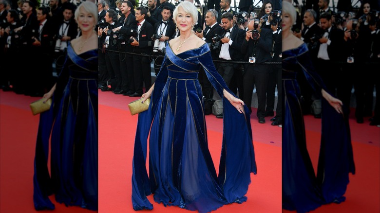 Helen Mirren posando en la alfombra roja en 2018 con un majestuoso vestido de terciopelo azul con mangas largas y fluidas.
