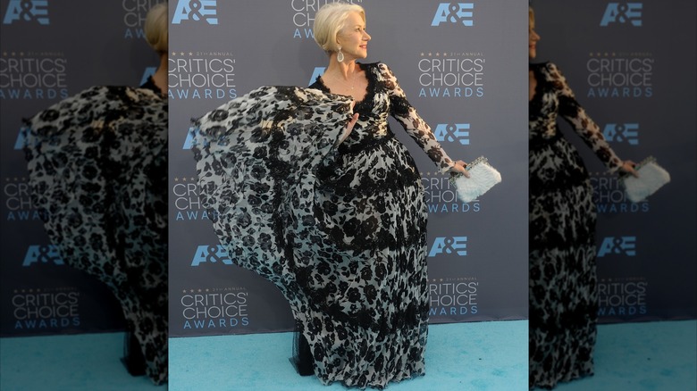 Helen Mirren posando en un evento de alfombra roja en 2016 con un vestido fluido en blanco y negro.