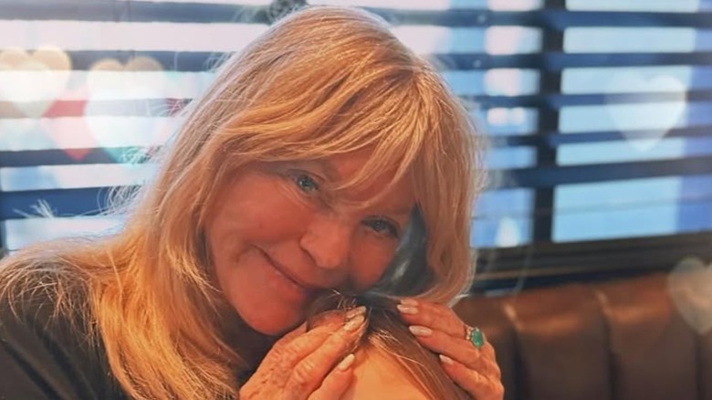 Goldie Hawn posando con las manos en la cabeza de su nieta en una foto sincera.