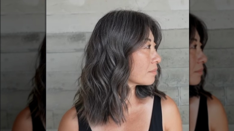 Mujer con lóbulo ondulado gris oscuro.