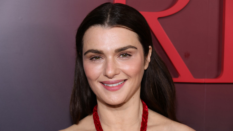 Rachel Weisz con el pelo liso hacia atrás y un vestido rojo