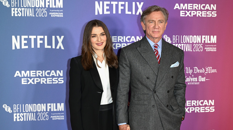 Rachel Weisz con un traje negro posando con Daniel Craig