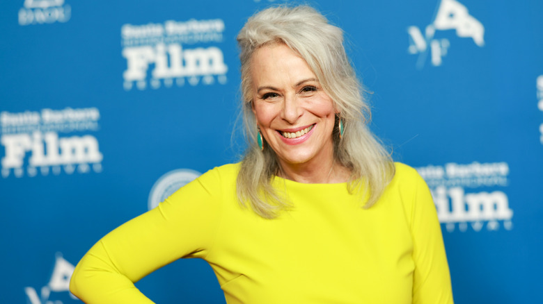 Jane Kaczmarek con un vestido amarillo brillante y aretes verdes en 2024
