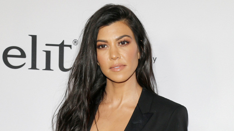 Kourtney Kardashian Barker fotografiada en un evento de alfombra roja vestida de negro.