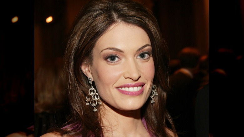 Kimberly Guilfoyle sonriendo en un evento en 2003 con aretes colgantes.