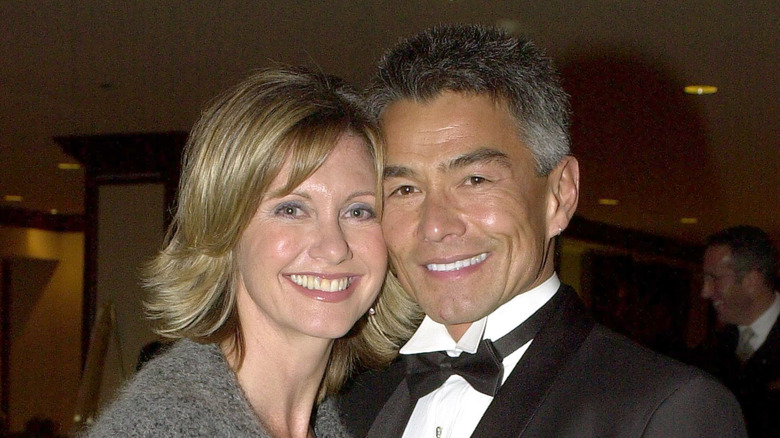 Olivia Newton-John luce un corte de pelo con flecos mientras posa con su rostro contra el de su exnovio, Patrick McDermott.