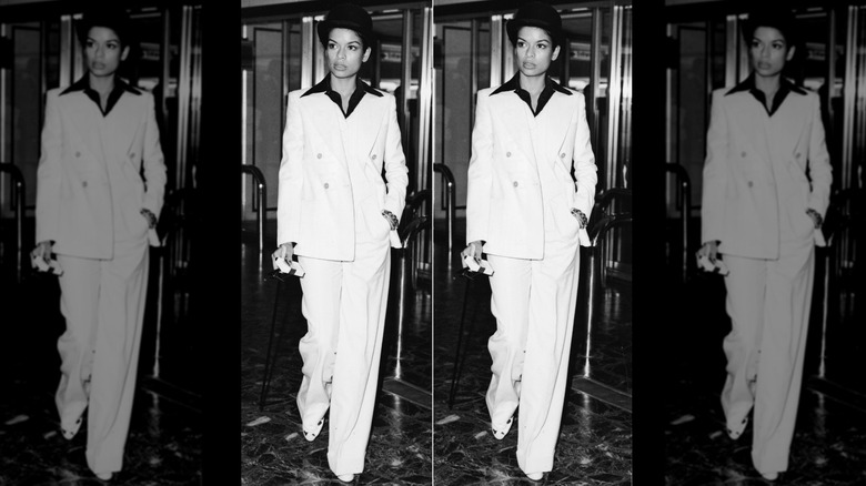 Bianca Jagger posando con un traje blanco en el aeropuerto de Heathrow en 1972.