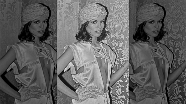 Bianca Jagger posando en una sesión de fotos en blanco y negro con un turbante y un atuendo ecléctico.