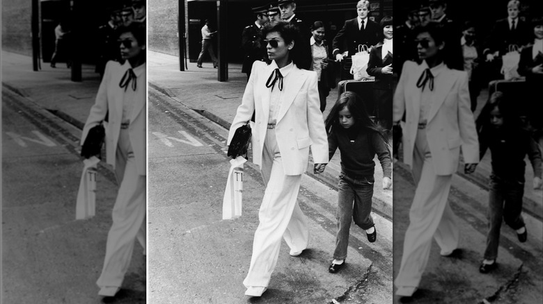 Bianca Jagger con un traje blanco cruzado de la mano de su hija Jade.
