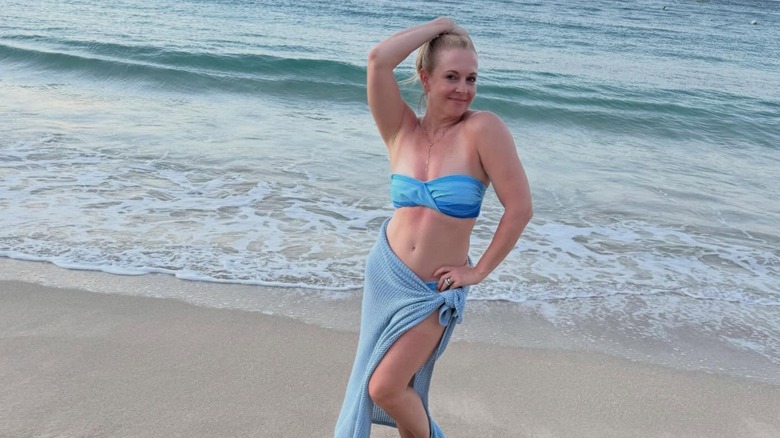 Melissa Joan Hart posando en bikini azul en la playa.