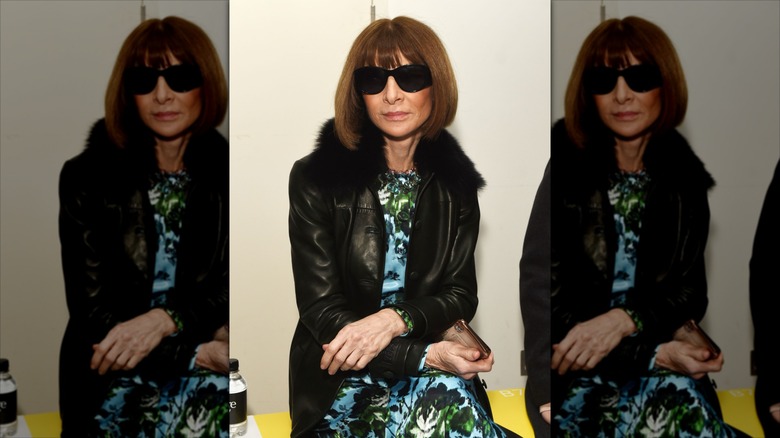Anna Wintour posa con cabello castaño luciendo gafas de sol y una chaqueta de cuero.