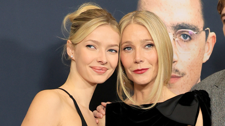 Apple Martin y Gwyneth Paltrow posan con sus cabezas juntas mientras asisten a un evento de alfombra roja.