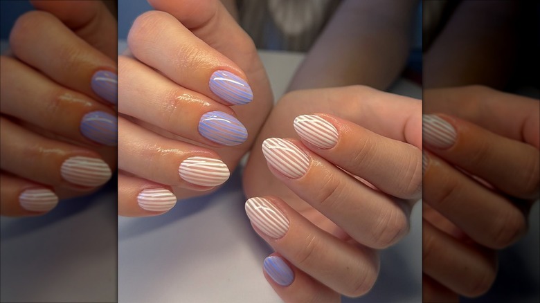 Uñas cortas con finas rayas azules y blancas.