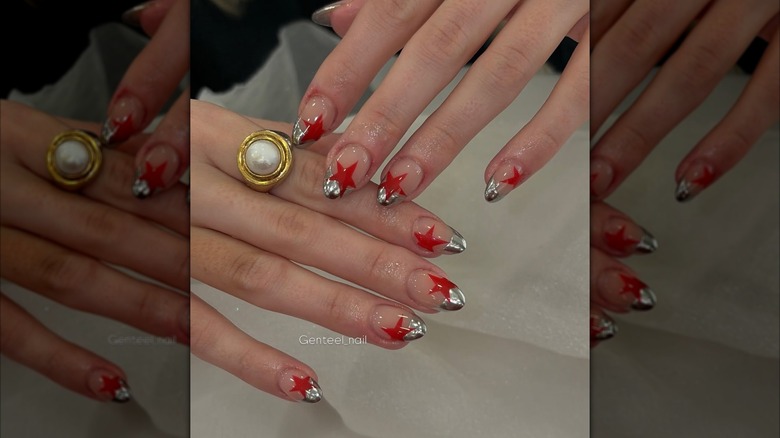 Uñas con punta francesa cromada y estrellas rojas.