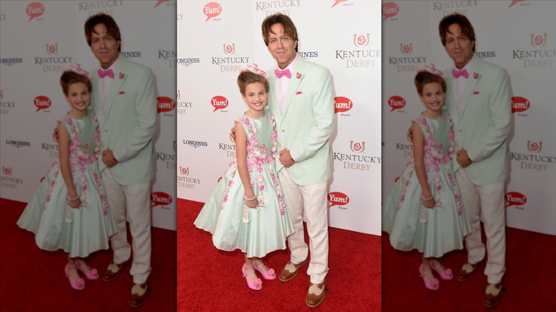 Dannielynn Birkhead sonríe junto a Larry Birkhead luciendo un vestido de flores verde menta