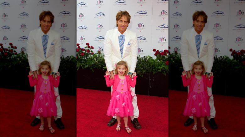 Dannielynn Birkhead sonríe frente a Larry Birkhead con un vestido rosa intenso