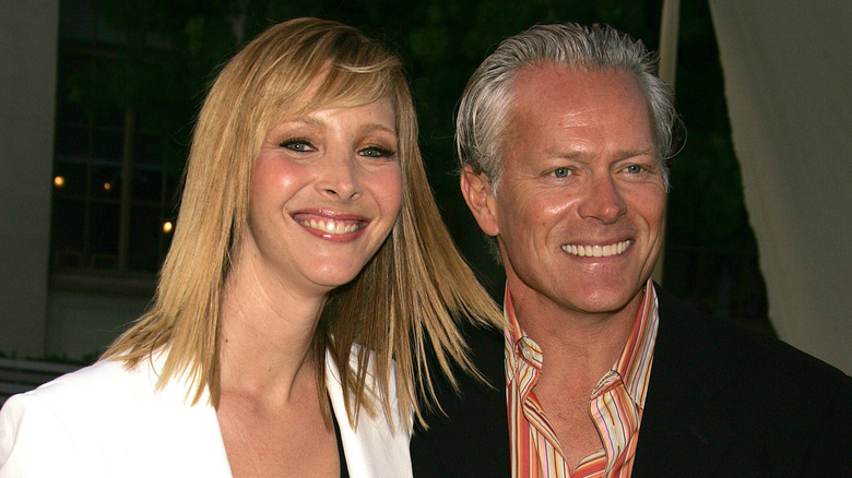 Lisa Kudrow con una chaqueta blanca posando con su marido Michael Stern
