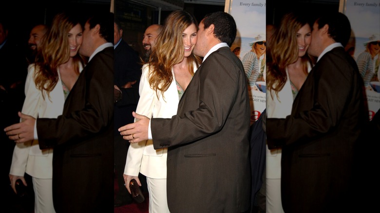 Jackie Sandler sonríe mientras Adam Sandler le susurra al oído