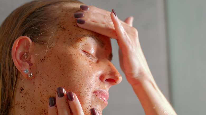 Una mujer que usa un exfoliante físico en la cara que podría ser demasiado fuerte para mujeres de 40 años.