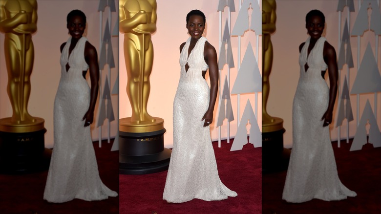 Lupita Nyong'o sonríe luciendo un vestido blanco de perlas