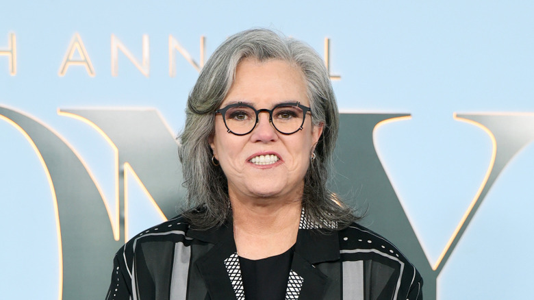 Rosie O'Donnell sonriendo y luciendo una chaqueta negra y gafas