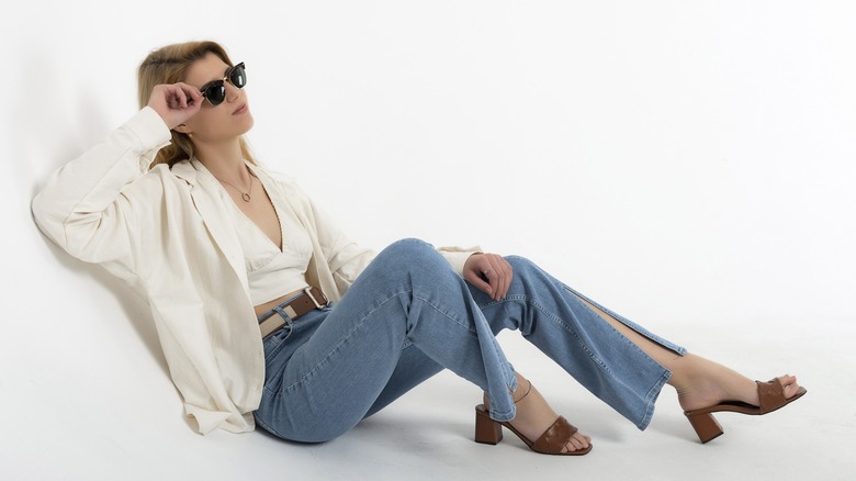 Una mujer vestida con jeans azules con dobladillo dividido.