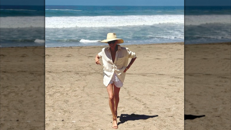 Meghan Markle vistiendo una chaqueta negra y pantalones negros mientras caminaba afuera.