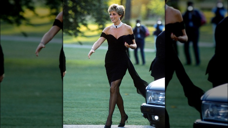 La princesa Diana con un vestido negro ajustado y con hombros descubiertos saliendo de un automóvil.