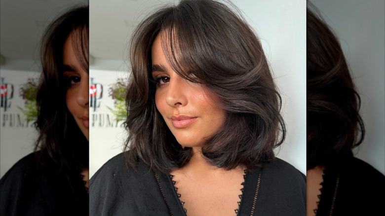 Una mujer con un corte de pelo bob mariposa con plumas.