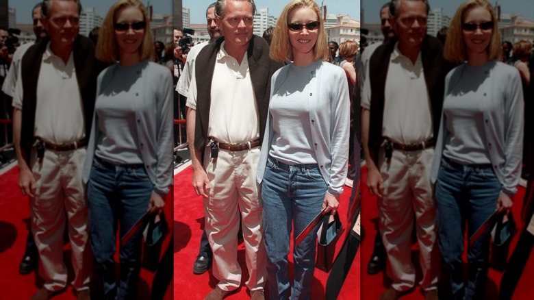 Lisa Kudrow posando en un evento de alfombra roja con mezclilla y un cárdigan.