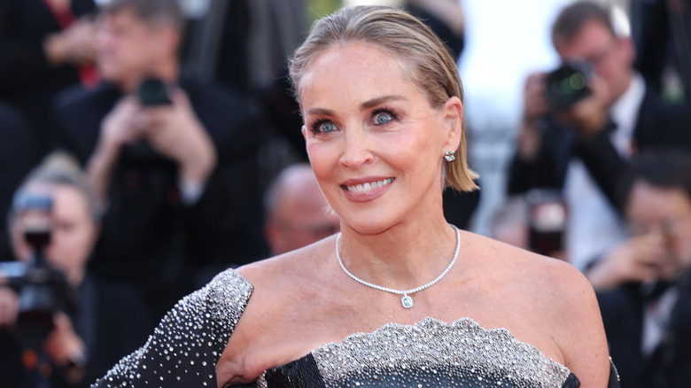 Sharon Stone con un vestido con tachuelas de diamantes de imitación y un shaw y un collar con colgante de diamantes en un evento de alfombra roja